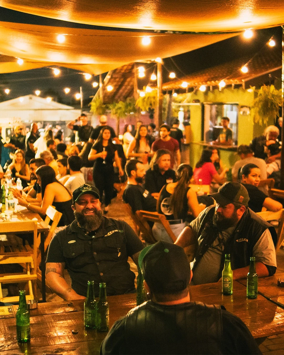 Público reunido no ambiente iluminado do bar